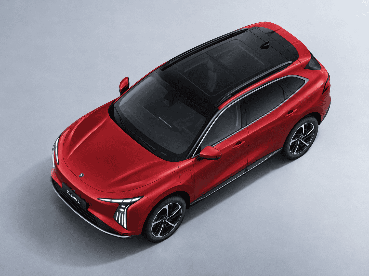 Top-down view of a red SUV with a black panoramic sunroof and chrome trim, parked on a light gray surface.
