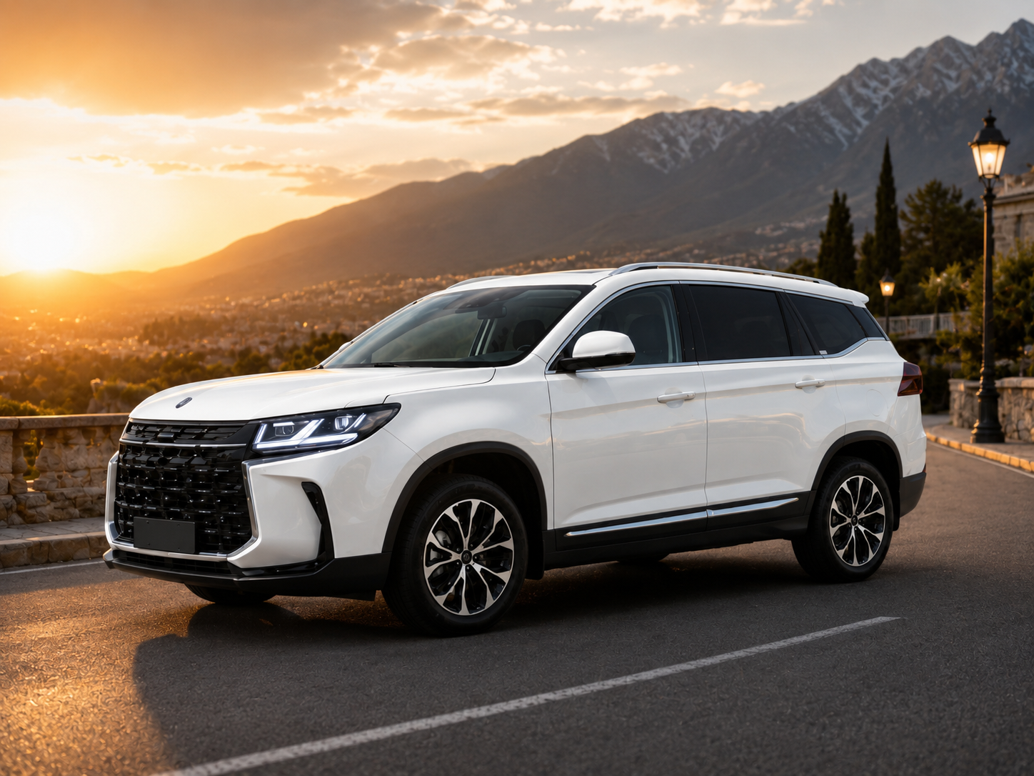 White SUV parked on a mountain road at sunset, with a stone railing and distant mountains in the background.