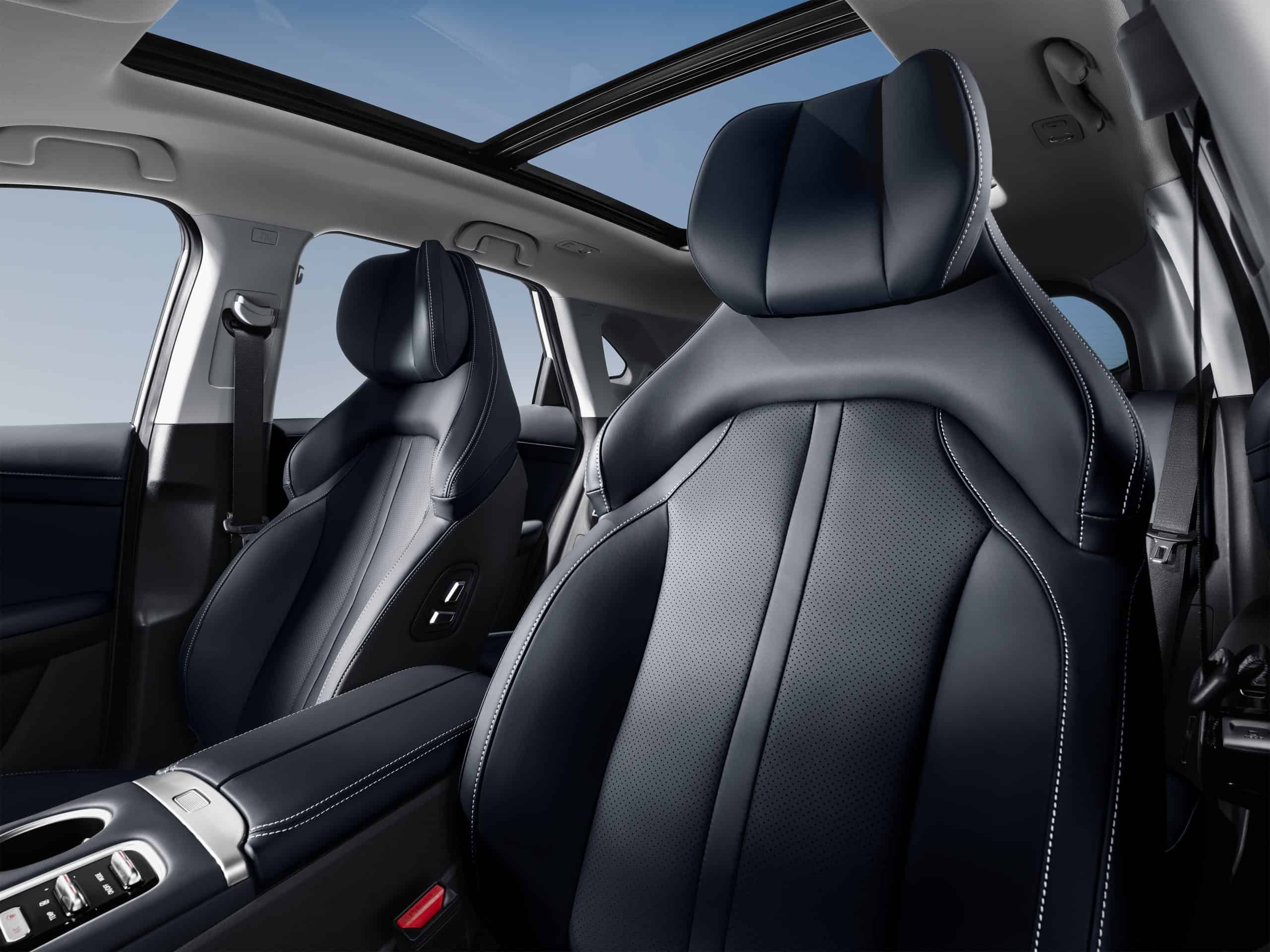 Luxurious car interior with black leather seats, contrast stitching, and a panoramic sunroof