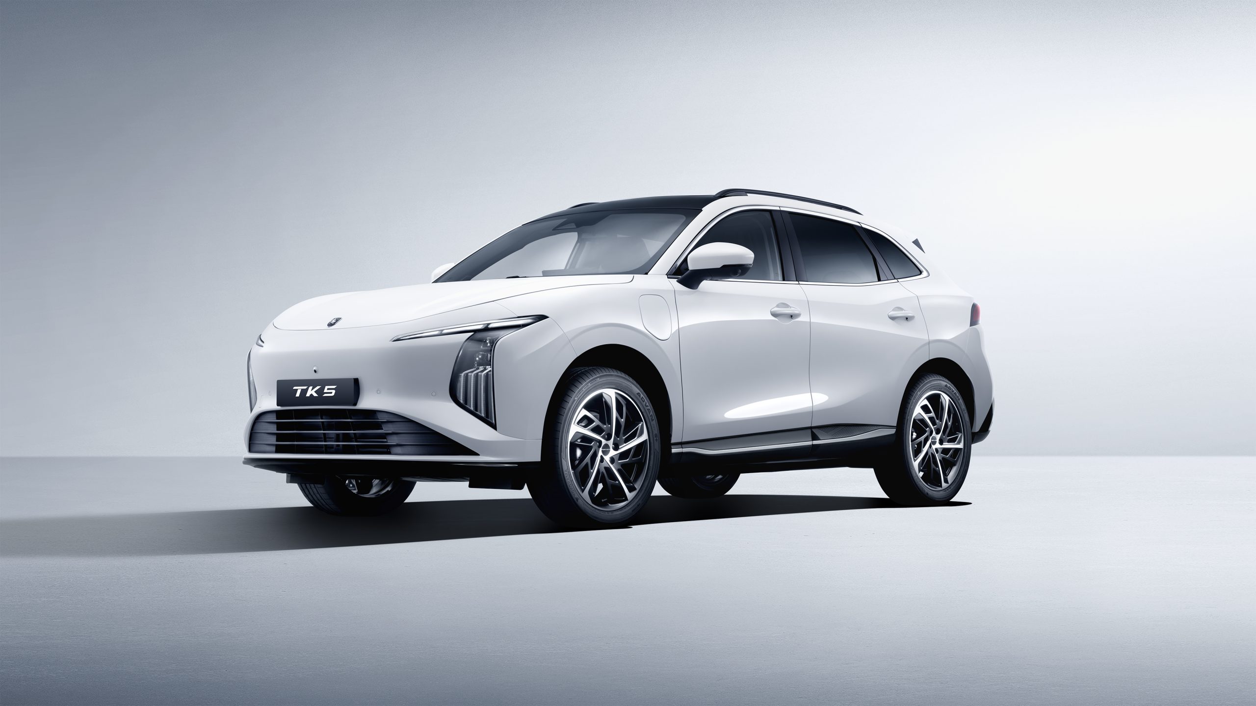 White SUV car shown from a low front-left angle with a sleek design and TK5 plate, in a light studio setting.